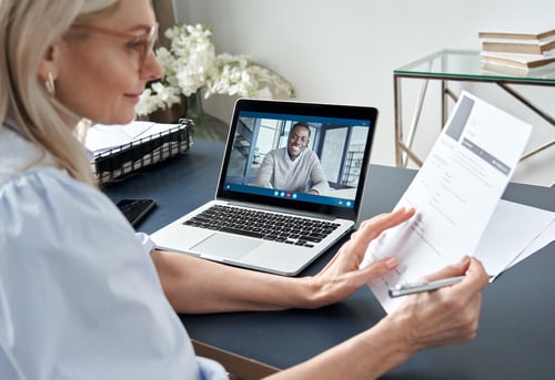 planned giving: man smiling in a video call and a woman holding a paper