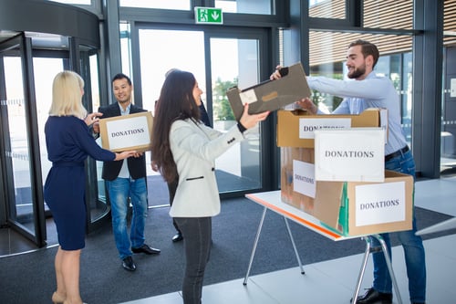 people holding donation boxes