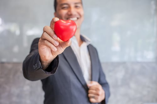 Donation request: Man in suit holding red heart